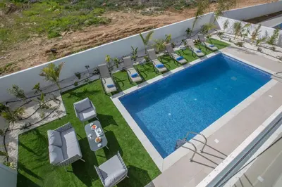 an overhead view of a swimming pool with lawn chairs and a pool at Olivine 3 Bedroom Villas in Protaras