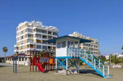 a playground on the beach next to a building at Mackenzie Castella Beachfront Suite in Larnaka