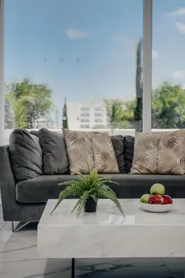 a living room with a couch and a table with fruit at Protaras Olivia Pearl Villa in Paralimni