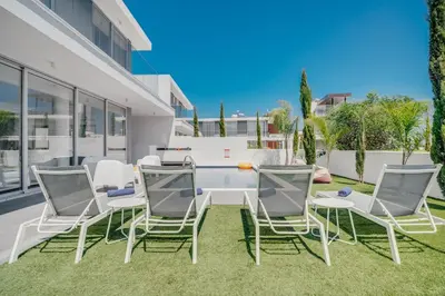 a group of chairs and a table in a yard at Protaras Olivia Pearl Villa in Paralimni