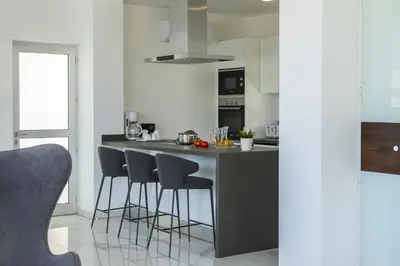 a kitchen with a island with bar stools at Protaras Olivine Pearl in Protaras