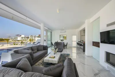 a living room with a couch and a table and a tv at Protaras Olivine Pearl in Protaras