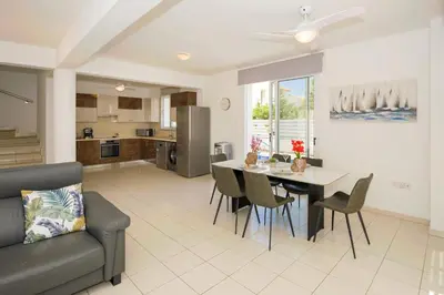 a kitchen and living room with a table and chairs at Villa Blue Sky in Protaras