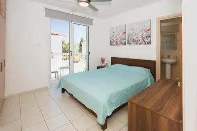 a bedroom with a blue bed and a balcony at Villa Blue Sky in Protaras