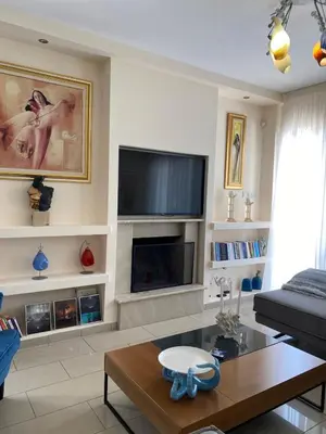 a living room with a fireplace and a tv at Ionion Beachfront Villa in Ayia Napa