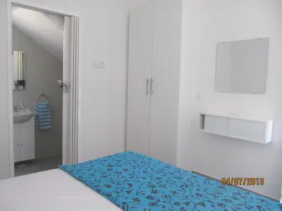a bedroom with a bed with a blue blanket at Sunny Holiday Apartments in Protaras