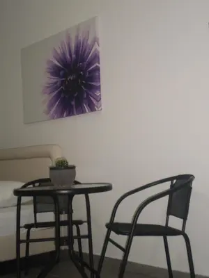 a table and two chairs and a purple painting on the wall at Sunny Holiday Apartments in Protaras