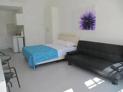 a bedroom with a bed and a couch at Sunny Holiday Apartments in Protaras