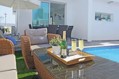 a patio with a table with two bottles of wine at Villa Caren in Paralimni