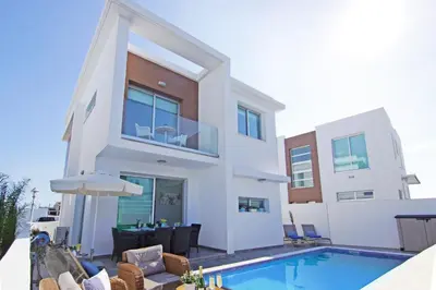 a house with a swimming pool in front of it at Villa Caren in Paralimni
