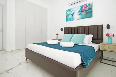 a bedroom with a large bed with blue and white pillows at Villa Paradisia in Ayia Napa
