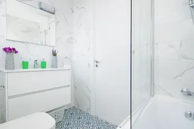 a white bathroom with a shower and a toilet at Villa Paradisia in Ayia Napa