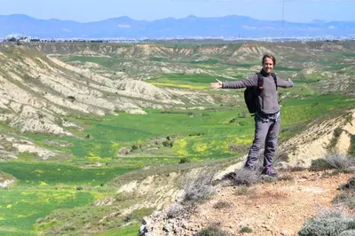 a man standing on a hill with his arms outstretched at Aperanti Agrotourism in Pera Orinis