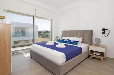 a bedroom with a large bed and a large window at Villa Amelia in Paralimni
