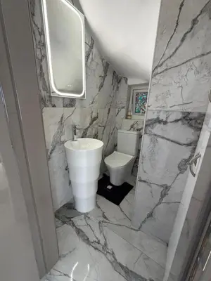 a marble bathroom with a toilet and a sink at Dene Hollow Oroklini in Voroklini