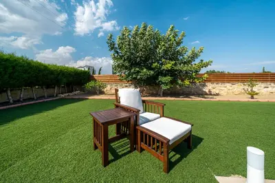 two chairs and a table on a lawn at Dene Hollow Oroklini in Voroklini
