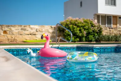 a swimming pool with a pink rubber duck and a toy at Dene Hollow Oroklini in Voroklini