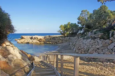 a set of stairs leading to a beach with the ocean at Lucile - Coralli Beachfront Apartment in Paralimni
