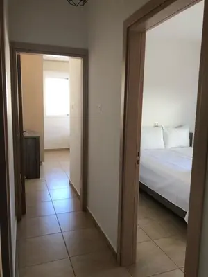 a room with a bed and a door leading to a bedroom at Mythical Sands Resort - Maria in Protaras
