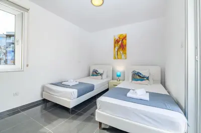 two beds in a room with a window at Blue Pelagos Villa in Protaras