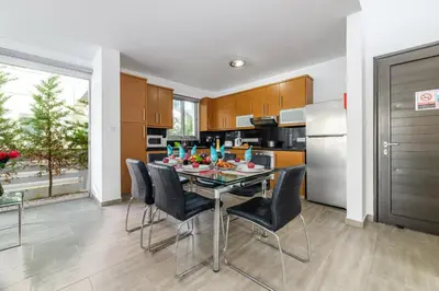 a dining room with a table and chairs in a kitchen at Blue Pelagos Villa in Protaras