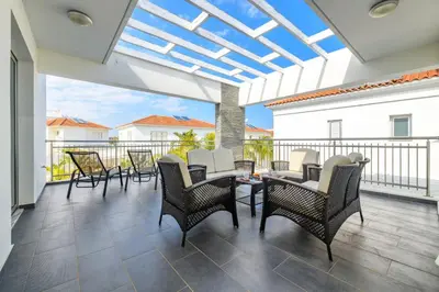 a patio with chairs and tables on a balcony at Blue Pelagos Villa in Protaras