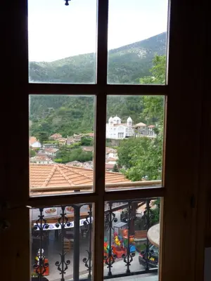 an open window with a view of a town at Mountain Rose Hotel & Restaurant in Pedoulas