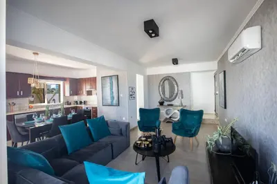 a living room with a couch and blue chairs at Tonia Seaview Villas in Protaras