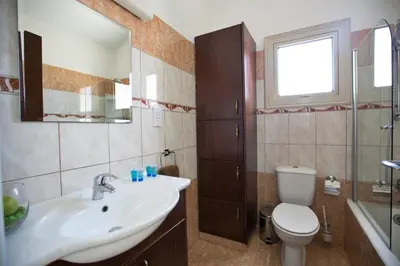 a bathroom with a sink and a toilet and a mirror at Tonia Seaview Villas in Protaras