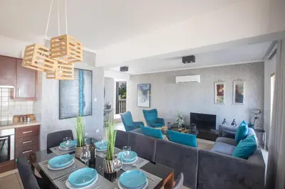 a living room with a couch and blue chairs at Tonia Seaview Villas in Protaras
