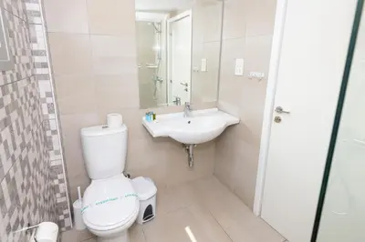 a bathroom with a toilet and a sink at Tofinis Hotel in Ayia Napa