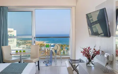 a living room with a view of the ocean at Tofinis Hotel in Ayia Napa