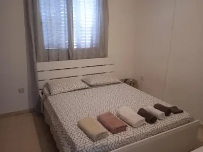a bedroom with a bed with three pillows and a window at Larnaca, Pervolia 1 bedroom seaside apartment in Pervolia
