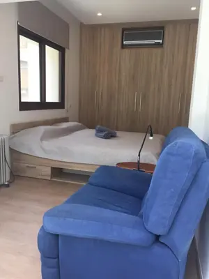 a bedroom with a bed and a blue chair at Modern 2 bedroom Beach Apartment in Limassol