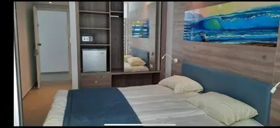 a bedroom with a bed and a tv in it at Karousos Beach Rooms in Ayia Napa