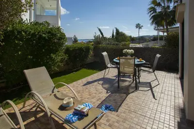 a patio with a table and chairs on a brick patio at Protaras Fig Tree Bay Villa Buena in Protaras