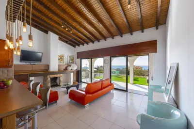 a living room with an orange couch and a television at Ayia Napa Ammos Sea View Villa in Ayia Napa