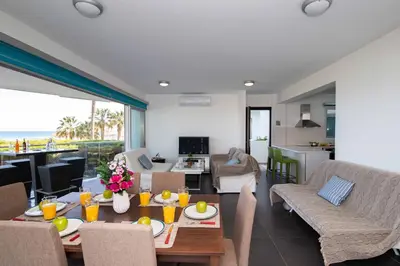a dining room and living room with a table and chairs at Apartment Trident 4 in Paralimni