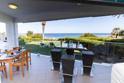 a patio with a table and chairs and the ocean at Apartment Trident 4 in Paralimni