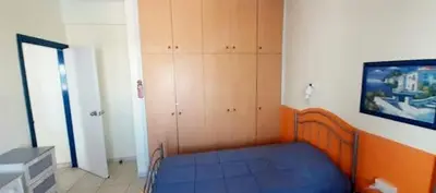 a small bedroom with a blue bed and wooden cabinets at Ayia Napa Sun Central in Ayia Napa