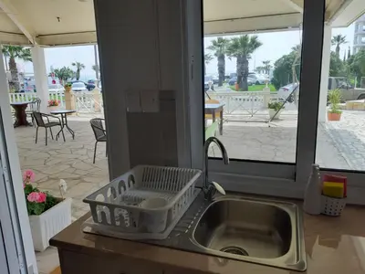 a kitchen sink with a dish drying rack next to a patio at ZORBAS Sea View No 5 in Larnaka