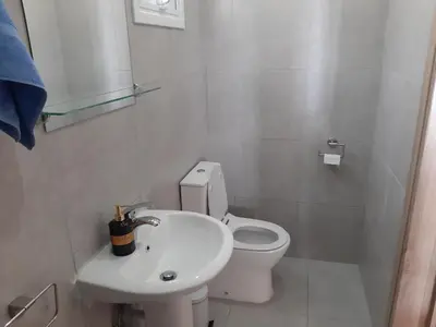 a white bathroom with a toilet and a sink at ZORBAS Sea View No 5 in Larnaka
