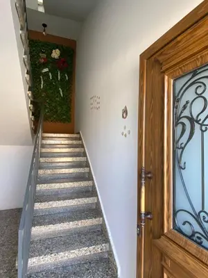 a staircase in a home with a wooden door at ElleNapa Apts & Studios in Ayia Napa