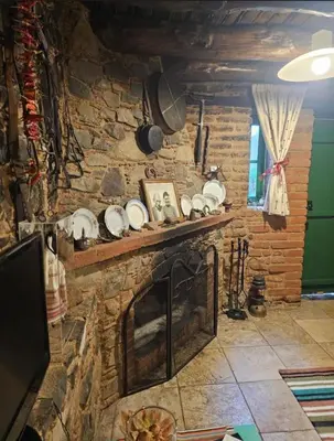 a living room with a stone fireplace with plates on it at Lasmari's Bouquet in Sykopetra