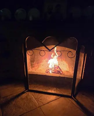 a fireplace with a fire in it in the dark at Lasmari's Bouquet in Sykopetra
