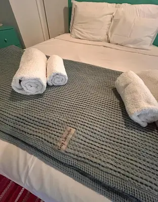 a bed with two towels on top of it at Lasmari's Bouquet in Sykopetra