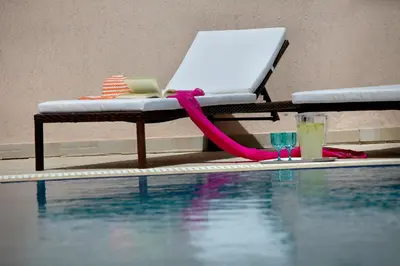 a table with a laptop next to a swimming pool at Protaras Villa Michelle 9 in Protaras