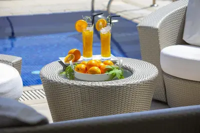 a table with a bowl of oranges and two drinks at Central Protaras Seaview Villa Zinnia in Protaras