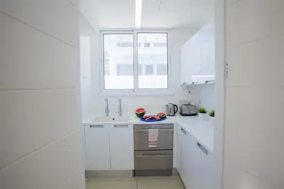 a white kitchen with a sink and a window at Central Protaras Seaview Villa Zinnia in Protaras