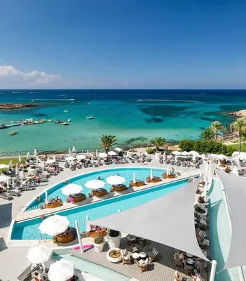 an aerial view of a resort with a pool and the ocean at King Jason Protaras - Designed for Adults by Louis Hotels in Protaras